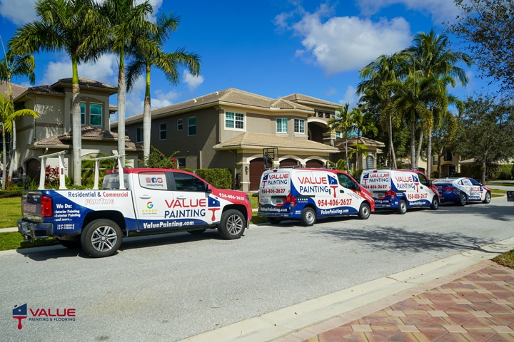 Four service trucks parked in front of a residential house