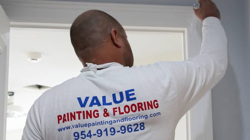 Professional painter applying paint to a door base in a residential house