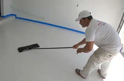 Value Painting and Flooring worker cleaning the surface before applying metallic epoxy flooring paint