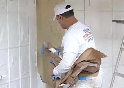 Worker cleaning up after interior house painting