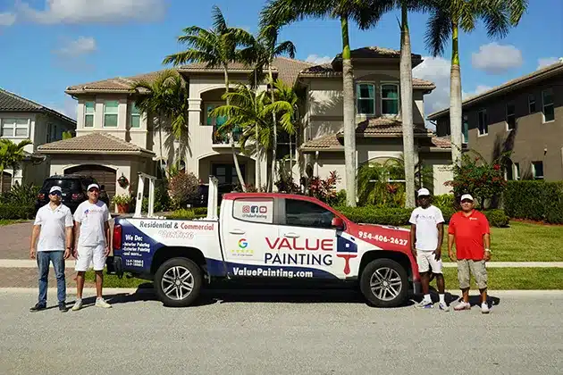 Value Painting and Flooring team and service truck in front of a home.