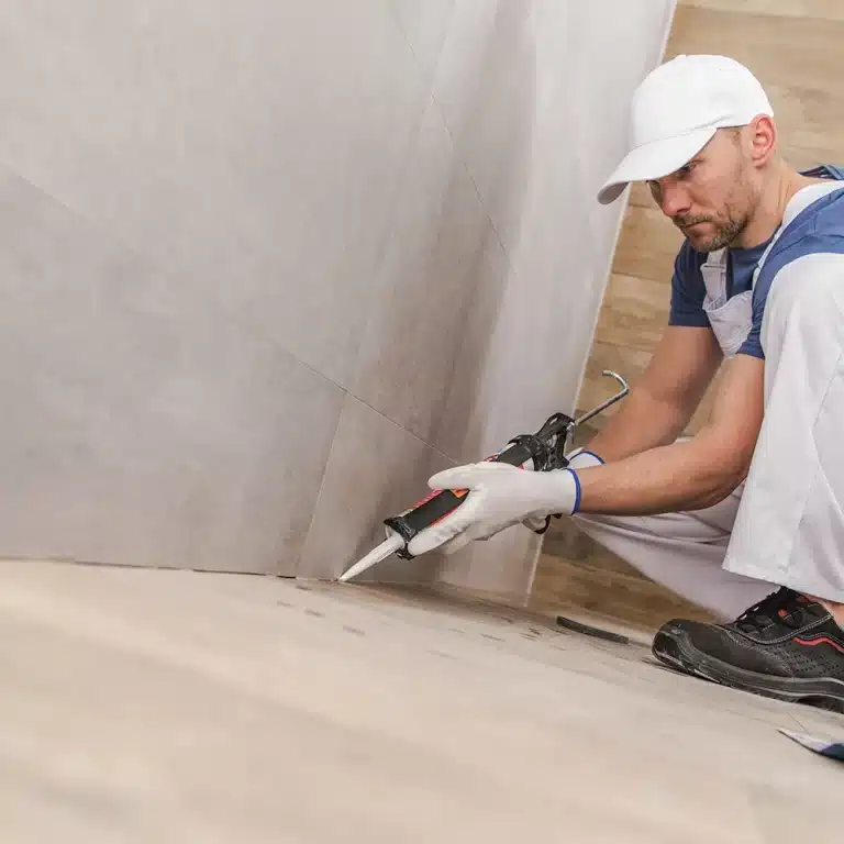 Worker applying sealer in a caulking and sealing project