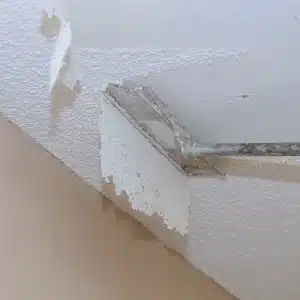 A person scraping off a popcorn ceiling