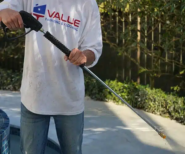 Value Painting and Flooring worker pressure washing exterior
