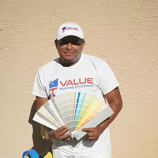 Value Painting and Flooring employee holding color swatch and smiling