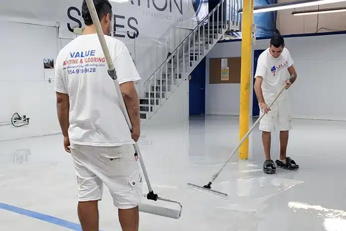 Value Painting & Flooring workers applying epoxy in a warehouse