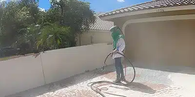 Value Painting worker sandblasting a walkway.