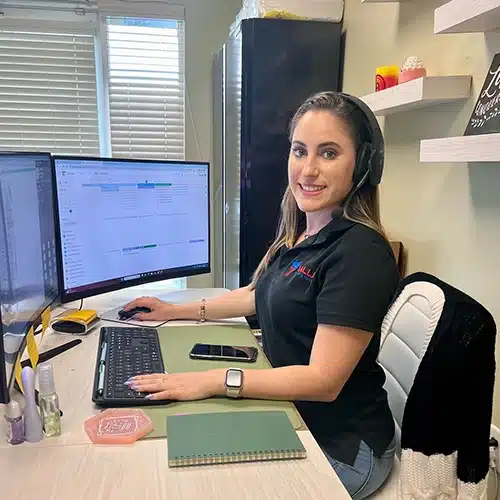 Office manager Davina smiling, ready to assist with your hardwood flooring queries.