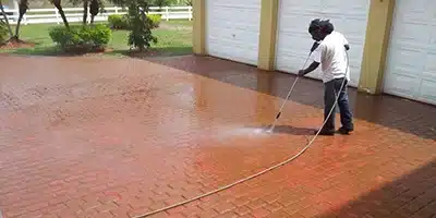 Value Painting worker power washing a walkway.