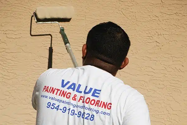 Value Painting and Flooring worker painting a home.