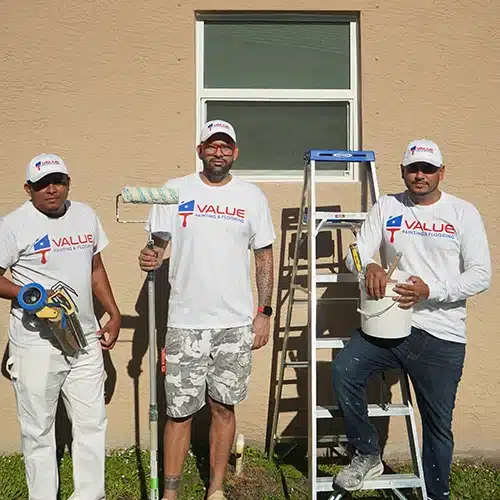 Value Painting and Flooring team with their painting tools outside a home.